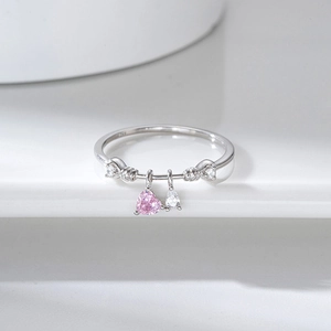 Detail of silver ring featuring a pink heart stone and clear teardrop-shaped zircon charm