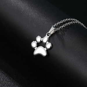 Macro shot of polished silver paw print pendant on a sleek O-chain necklace