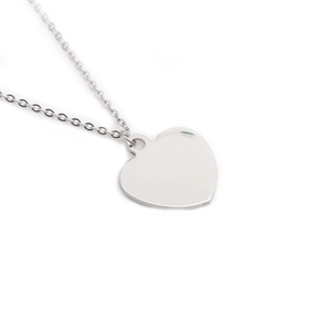Polished silver titanium steel heart pendant necklace with thin metal chain on white background