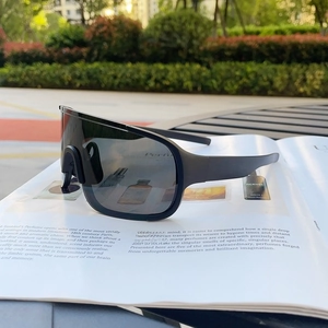 Outdoor lifestyle view of matte black wrap-around sports sunglasses on a magazine