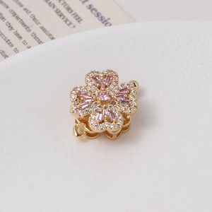 Macro detail of a rotating flower clasp with pink cubic zirconia and gold plating