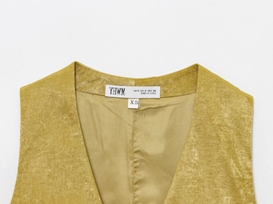 Dettaglio del gilet in raso dorato con bottoni d'oro e etichetta del marchio YHWM sul collo