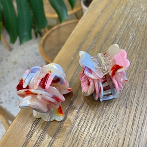 Detail of colorful marble pattern hair claws with spring mechanism on wooden background