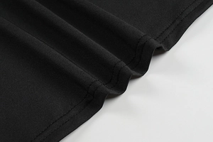 Detail of the double-needle flat seam stitching on a black bodycon dress hemline