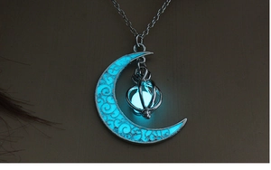 Close-up of alloy moon pendant with glowing blue luminous stone on silver chain