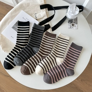 Flat lay of five pairs striped cotton socks in retro aesthetic with minimal props