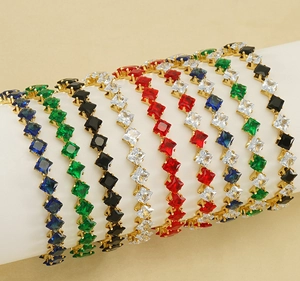 Detailed row of gold-plated tennis bracelets with multi-colored square-cut gemstones