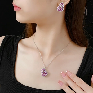 Close-up of model wearing silver hollow gourd pendant necklace and pink zircon earrings