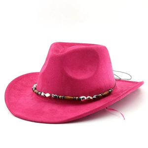 Gros plan sur un chapeau de cowboy en daim rose avec bandeau perlé ethnique et breloques