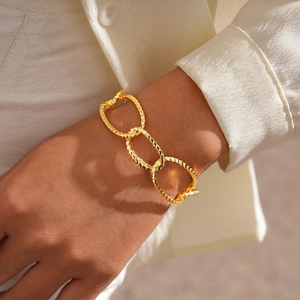 Detailed view of 18K gold plated textured chain link cuff bracelet on model wrist