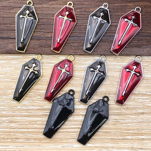 Detailed macro view of various gothic coffin charms with cross and enamel finish for DIY jewelry