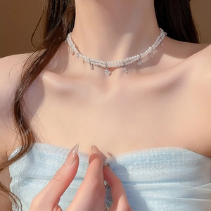 Close-up of elegant double-layer pearl necklace featuring a teardrop zircon pendant