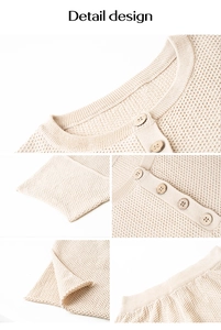 Detail design showing beige waffle knit texture with round wooden buttons on the sleeve and hem