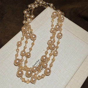 Detail of layered vintage French style necklace with champagne pearls and crystal beads