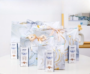 Detail of four marble pattern gift bags with satin ribbons in various sizes