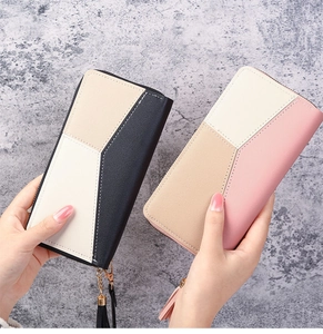 Close-up of long zip wallets with geometric color block design and gold tassel zippers