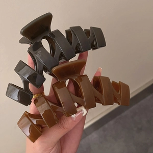 Close-up of 13cm oversized acrylic hair claw clips in three earthy brown gradient tones
