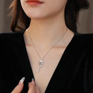 Detailed view of women's silver hourglass pendant necklace with zircon on black velvet