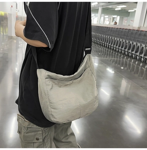 Close-up of grey nylon crossbody bag showing the adjustable strap and smooth fabric texture