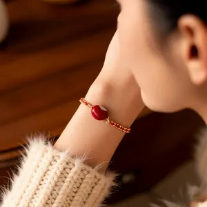 18 Karat vergoldetes Armband mit rotem Apfelanhänger und Blatt am Handgelenk