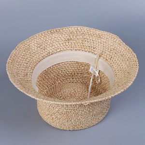 Detailed macro view of the hand-woven raffia texture and inner sweatband of the sun hat