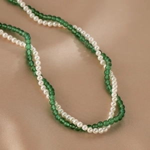 Detailed shot of double-layer necklace with green agate beads and white pearls on silk