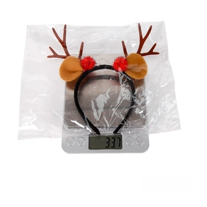 Detailed view of red Christmas reindeer headband being weighed on a scale for shipping