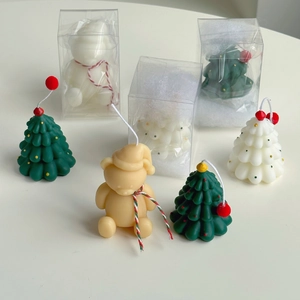 Detailed view of handmade Christmas tree and bear candles in festive gift packaging