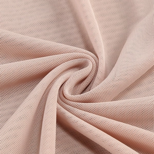 Macro shot of breathable nude pink mesh knit fabric with soft draped texture detail