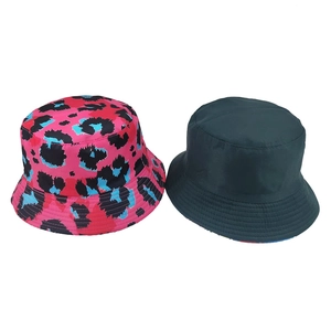 Reversible bucket hat featuring vibrant pink leopard print and solid dark green design