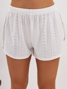 Close-up of white summer pajama shorts with elastic waist and intricate eyelet embroidery