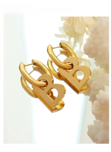 Detailed view of gold-plated geometric B-shaped letter earrings with a polished mirror finish