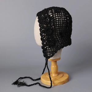 Detail of black crochet bandana featuring hollow knit patterns and sequins with fringe straps
