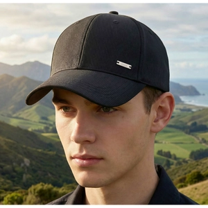 Close-up of black corduroy baseball cap texture with silver metal Cavallis brand tag
