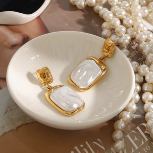 Detailed close-up of baroque pearl earrings in gold setting on an elegant display