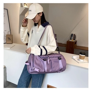 Detail of purple waterproof nylon travel bag with multiple pockets and shoulder strap