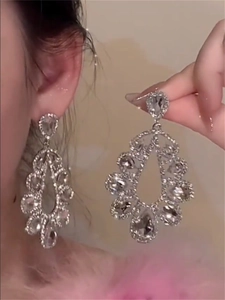 Detailed macro view of silver teardrop dangle earrings with sparkling crystals