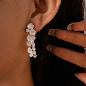 Detailed macro of vintage silver layered flower earrings with lustrous white pearls