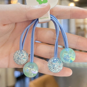 Close-up of blue elastic hair ties with glitter and pearlescent beads for girls