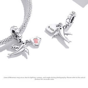 Macro shot of S925 silver bird charm with pink enamel heart envelope for DIY bracelets