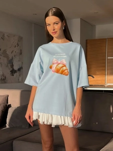 Λεπτομέρεια γαλάζιου oversized βαμβακερού T-shirt με σχέδιο κρουασάν και φιόγκο