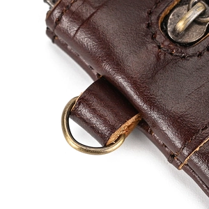 Macro detail of dark brown leather coin purse showing premium stitching and vintage zipper