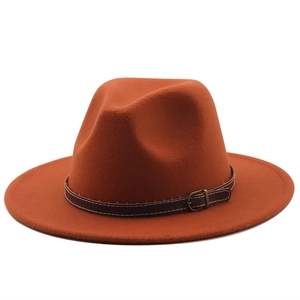 Burnt orange wool fedora featuring a brown leather band with metallic buckle and white stitching