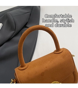 Close-up of structured round handle and gold metal fastener on brown suede handbag