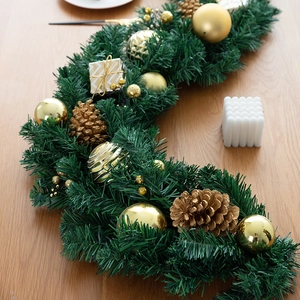 Christmas pine needle garland with gold pinecones, ornaments and gift box decoration