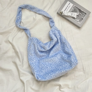 Macro shot of fluffy light blue leopard print plush tote bag on white fabric background