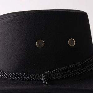 Detail view of black faux suede cowboy hat with metal eyelets and braided band decoration