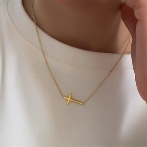 Detail of gold-plated stainless steel cross necklace worn on neck with O-link chain
