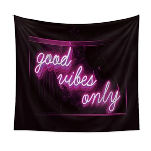 Detail of black tapestry with pink neon 'good vibes only' lettering for wall decor