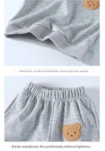 Close-up of kids fleece tracksuit with ribbed hem, elastic waist and bear embroidery